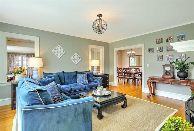 living area featuring baseboards, an inviting chandelier, and light wood-style floors