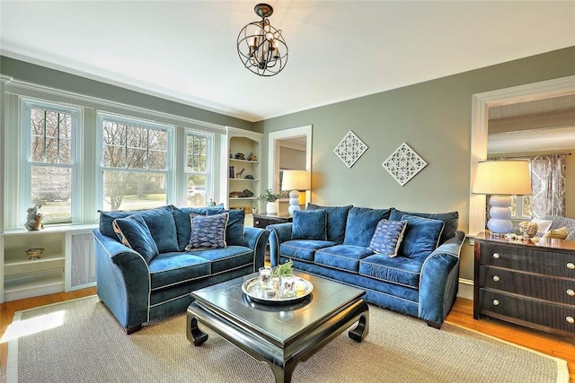 living room featuring a chandelier, crown molding, and wood finished floors