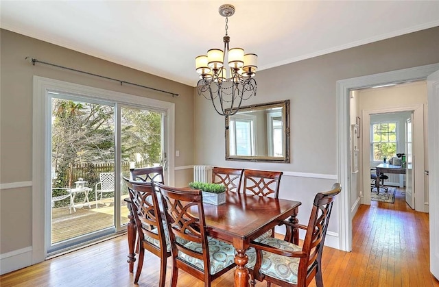 dining space featuring baseboards, a notable chandelier, and light wood-style floors