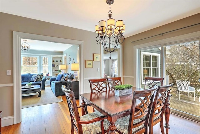 dining space with light wood finished floors and a notable chandelier