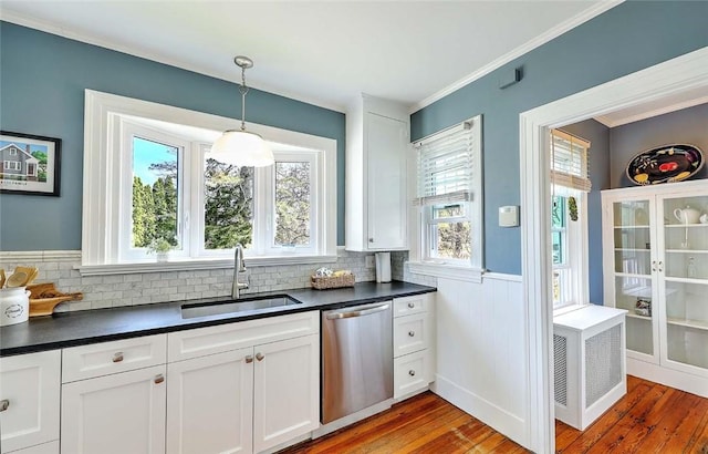 kitchen featuring wood-type flooring, dishwasher, a sink, and dark countertops