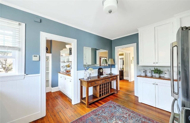 kitchen with freestanding refrigerator, wood-type flooring, and white cabinetry