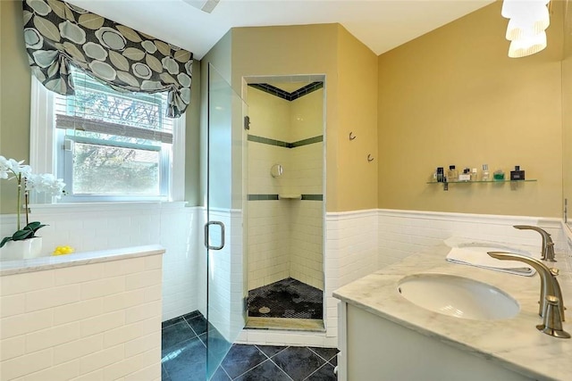 full bathroom with a shower stall, tile patterned floors, tile walls, and a sink