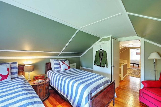 bedroom featuring hardwood / wood-style floors and vaulted ceiling