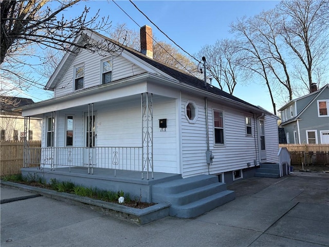 42 Harris Ave, Cranston, RI 02920 - exterior space featuring fence, a chimney, and covered porch