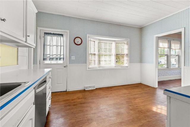 kitchen with wallpapered walls, wainscoting, and wood finished floors