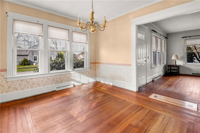 unfurnished dining area with crown molding, a chandelier, hardwood / wood-style floors, wallpapered walls, and visible vents