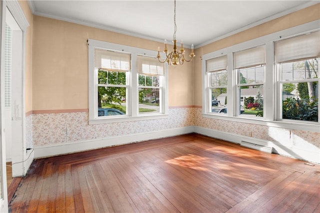 unfurnished dining area featuring crown molding, baseboards, hardwood / wood-style flooring, and a notable chandelier