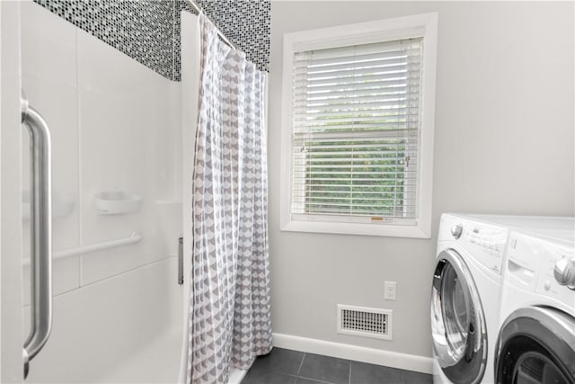 laundry room featuring laundry area, baseboards, dark tile patterned flooring, visible vents, and washer and clothes dryer