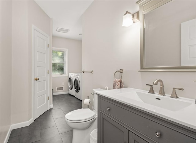 bathroom featuring independent washer and dryer, tile patterned flooring, toilet, baseboards, and visible vents