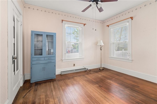 unfurnished room featuring baseboards, a ceiling fan, and hardwood / wood-style flooring