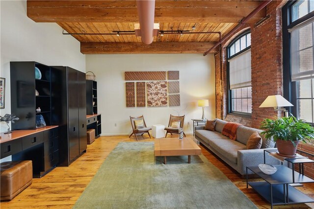 living area with track lighting, wood ceiling, light wood finished floors, and beam ceiling