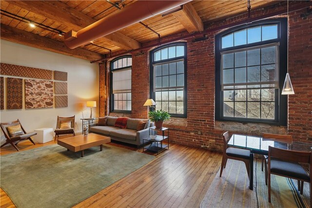 living room featuring wood ceiling, brick wall, beamed ceiling, and hardwood / wood-style flooring