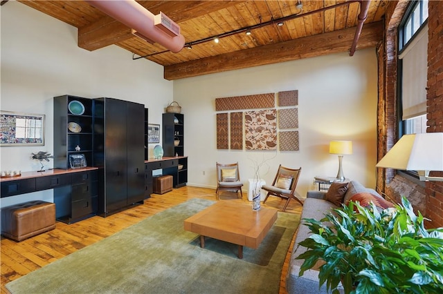 living area with light wood-style floors, wood ceiling, and beamed ceiling