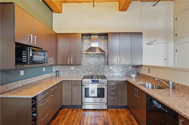 kitchen with a sink, wall chimney range hood, dark wood-style flooring, black appliances, and light stone counters