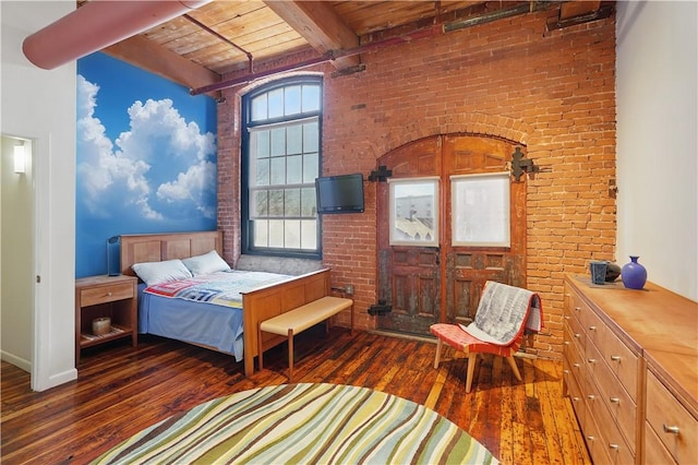 bedroom featuring beamed ceiling, wooden ceiling, hardwood / wood-style floors, and brick wall