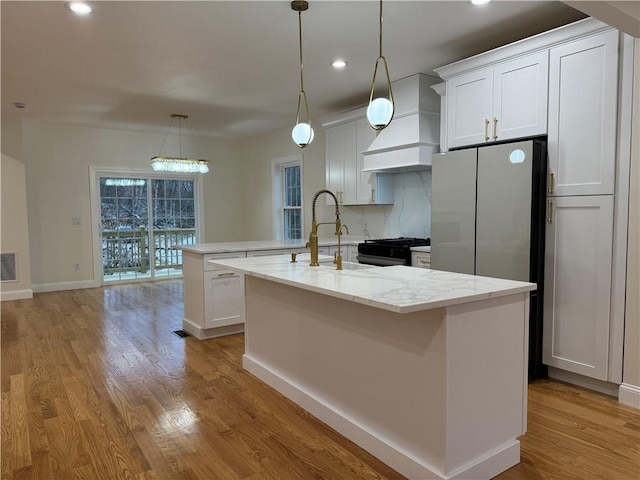 1404 Hunting Hill Dr, Cumberland, RI 02864 - kitchen featuring custom exhaust hood, recessed lighting, light wood-style floors, an island with sink, and appliances with stainless steel finishes