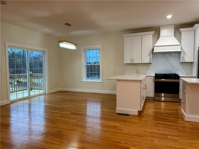 1404 Hunting Hill Dr, Cumberland, RI 02864 - kitchen with premium range hood, tasteful backsplash, gas stove, and light countertops