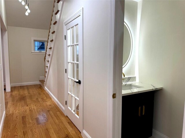 1404 Hunting Hill Dr, Cumberland, RI 02864 - hallway with stairway, baseboards, a sink, and light wood finished floors