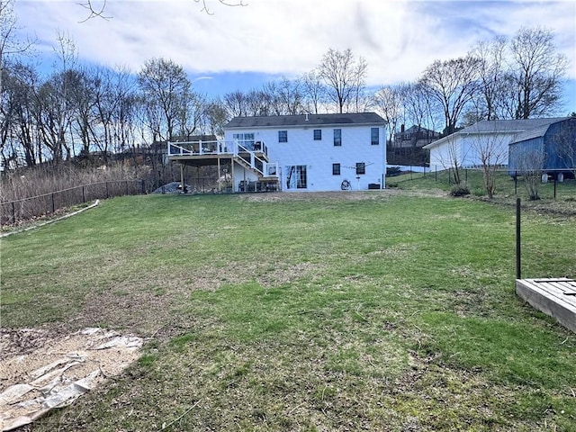 view of yard featuring a deck, stairway, and fence