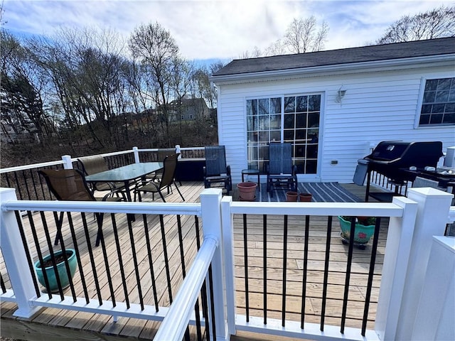 wooden deck featuring outdoor dining space and a grill
