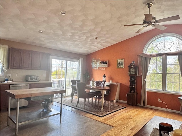 dining room featuring ceiling fan, light wood-type flooring, plenty of natural light, and vaulted ceiling
