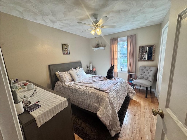 bedroom with a ceiling fan and light wood-style flooring