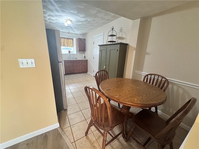 dining room featuring baseboards and light tile patterned floors