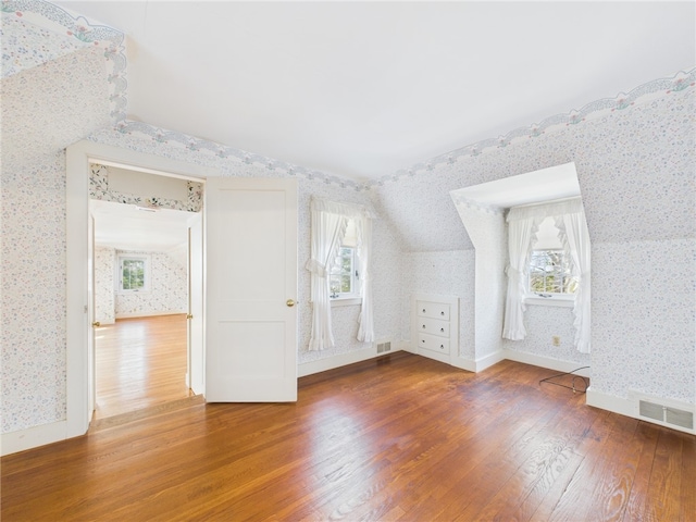 23 Rockland Dr, South Kingstown, RI 02879 - bonus room with visible vents, vaulted ceiling, wallpapered walls, and wood finished floors