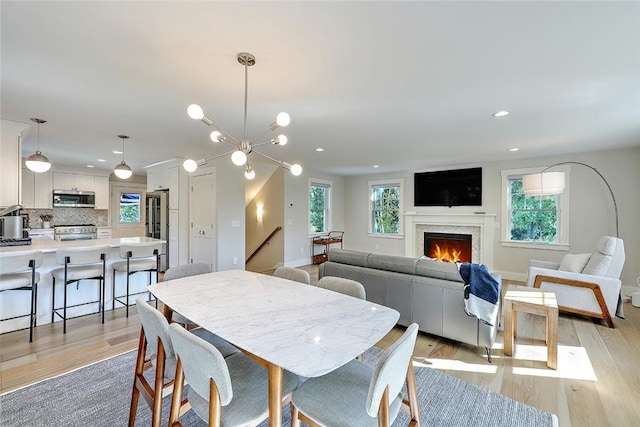 137 Rosebriar Ave, South Kingstown, RI 02879 - dining area with recessed lighting, light wood finished floors, baseboards, and a warm lit fireplace