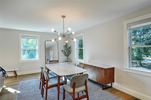 137 Rosebriar Ave, South Kingstown, RI 02879 - dining area with a chandelier, wood finished floors, baseboards, and a wealth of natural light