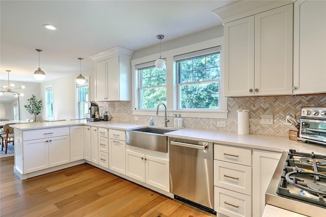 137 Rosebriar Ave, South Kingstown, RI 02879 - kitchen with dishwasher, light wood-type flooring, a peninsula, tasteful backsplash, and white cabinetry