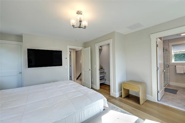 137 Rosebriar Ave, South Kingstown, RI 02879 - bedroom featuring baseboards, light wood-type flooring, an inviting chandelier, a walk in closet, and visible vents