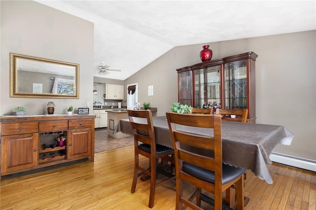 dining space featuring lofted ceiling, light wood-style flooring, and ceiling fan