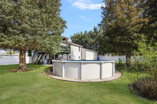 exterior space featuring stairway, a deck, a lawn, and a fenced backyard