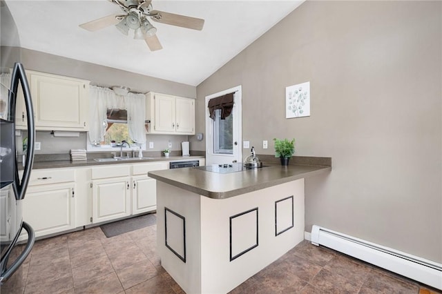 kitchen featuring a sink, a peninsula, lofted ceiling, baseboard heating, and white cabinets