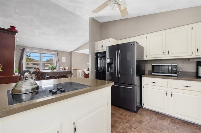 kitchen with black appliances, vaulted ceiling, ceiling fan, white cabinets, and dark countertops