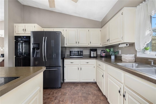 kitchen featuring white cabinets, dark countertops, vaulted ceiling, and black appliances