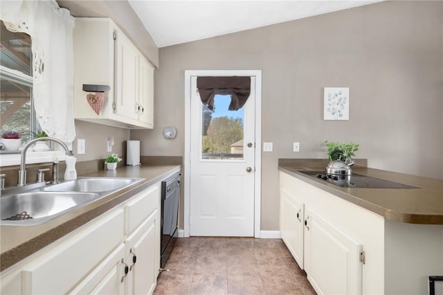 kitchen with a sink, white cabinetry, baseboards, black appliances, and vaulted ceiling