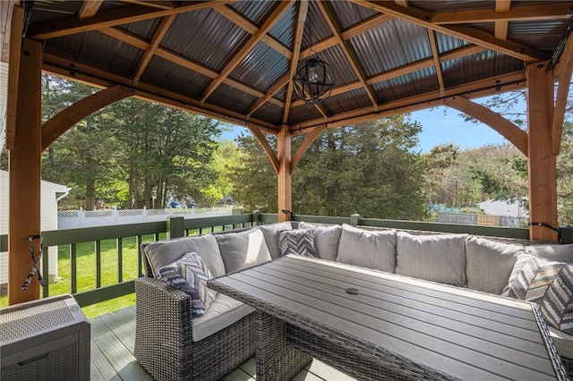 wooden deck featuring outdoor lounge area, fence, a gazebo, and a lawn
