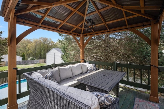 wooden deck featuring a gazebo, a yard, a storage unit, a fenced in pool, and an outdoor hangout area
