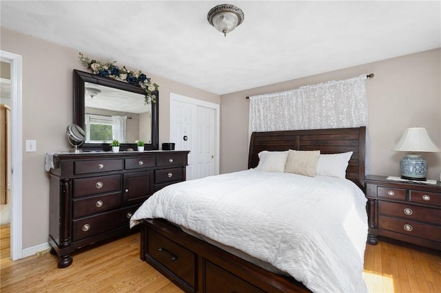 bedroom featuring baseboards, a closet, and light wood-style flooring