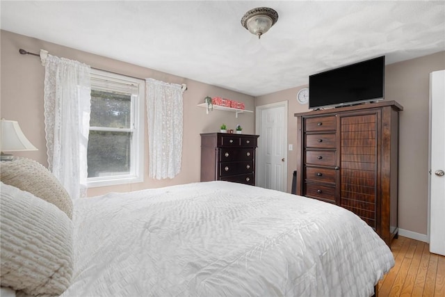 bedroom featuring baseboards and light wood finished floors