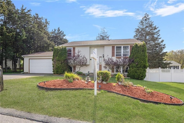 split foyer home with a front yard, driveway, and fence