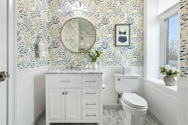 78 Rhode Island Ave Unit 5, Newport, RI 02840 - bathroom with wallpapered walls, tile walls, a wainscoted wall, toilet, and vanity