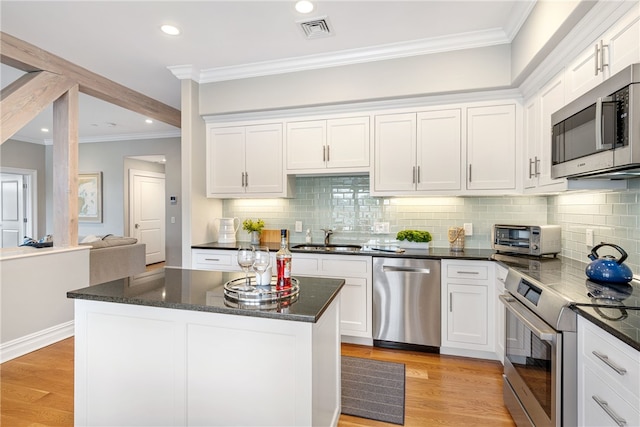 78 Rhode Island Ave Unit 5, Newport, RI 02840 - kitchen with a toaster, stainless steel appliances, a sink, visible vents, and crown molding