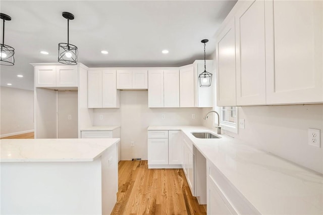 kitchen with a sink, light wood-style flooring, recessed lighting, and white cabinets