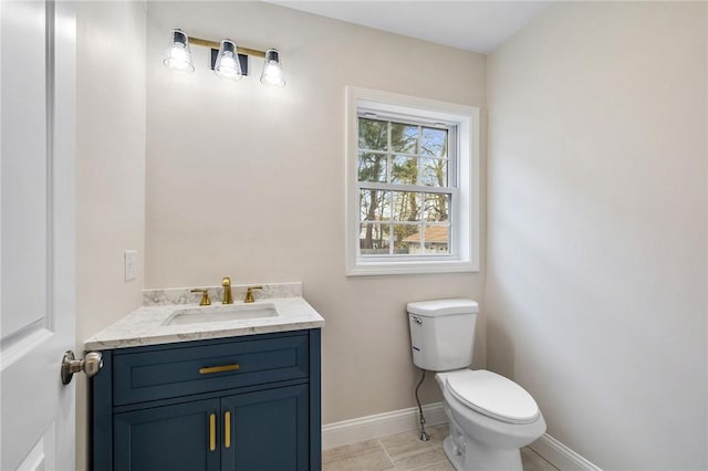 bathroom with vanity, baseboards, and toilet