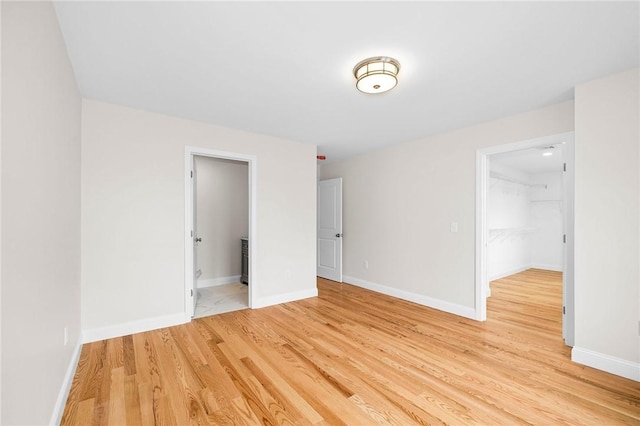 spare room featuring light wood-style floors and baseboards