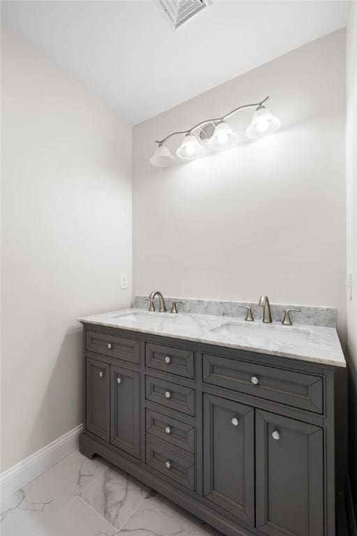 bathroom featuring a sink, visible vents, baseboards, and marble finish floor